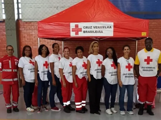 Voluntários reunidos em frente à tenda da Cruz Vermelha Brasileira